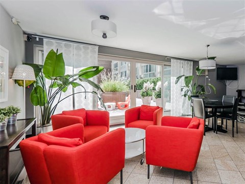 a living room with red chairs and a table