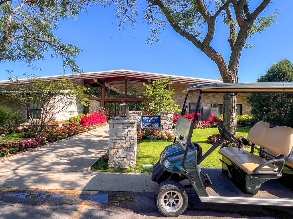 A golf cart is parked in front of a house with a sign that says "Welcome to Paradise.".