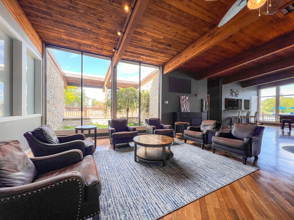A living room with brown leather chairs and a wooden ceiling.