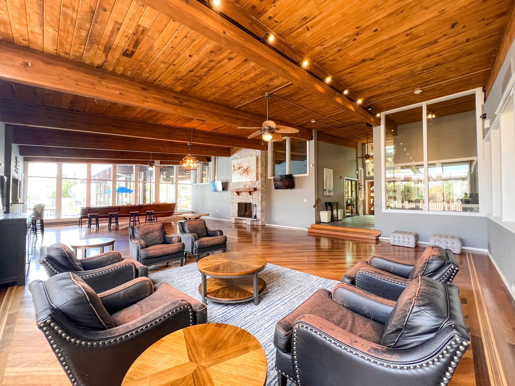 A living room with leather chairs and a wooden ceiling.