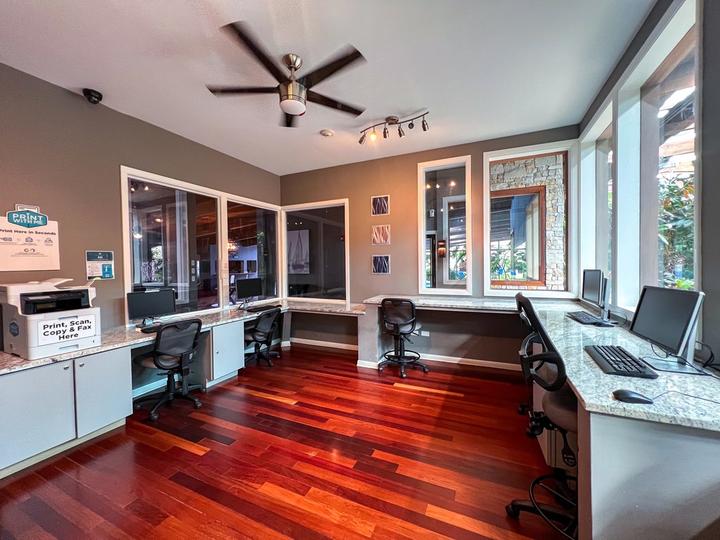 A room with a wood floor and a ceiling fan.