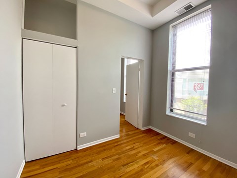 a bedroom with a door to a closet and a window