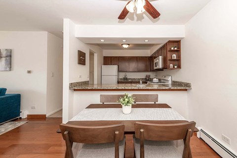 a dining room with a table and chairs and a kitchen