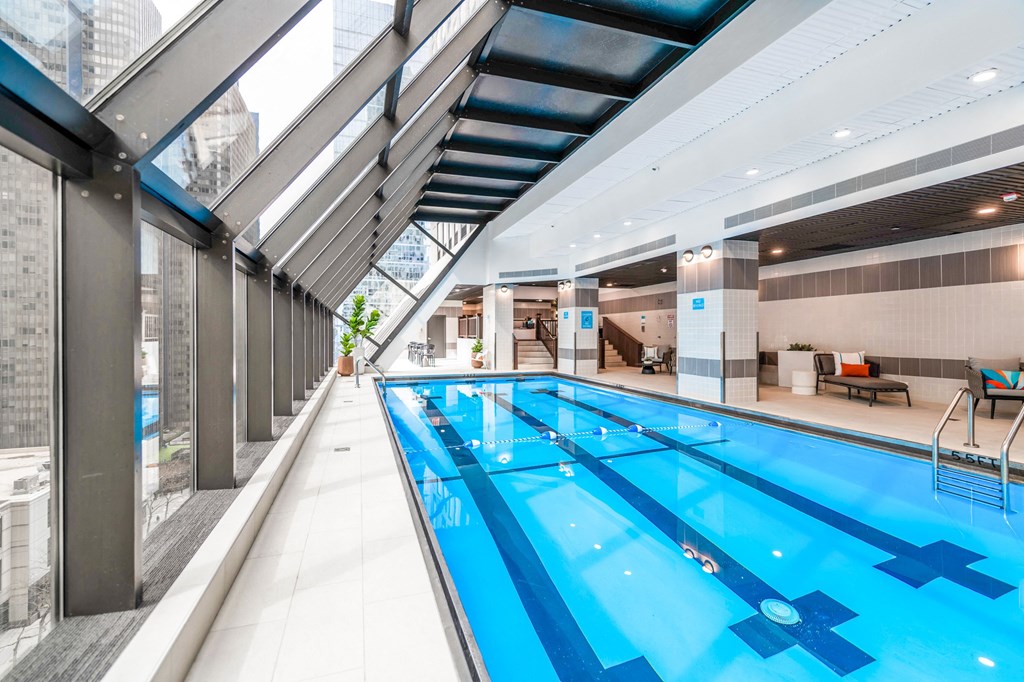 a large indoor swimming pool with a glass ceiling chicago apartment
