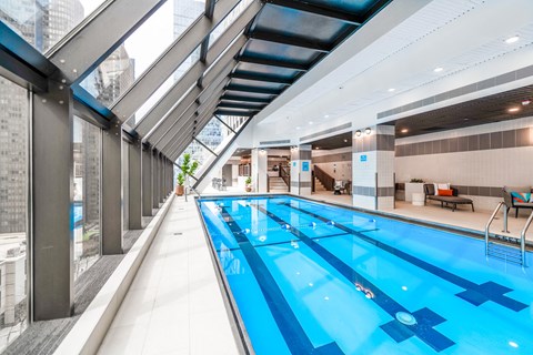 a large indoor swimming pool with a glass ceiling chicago apartment