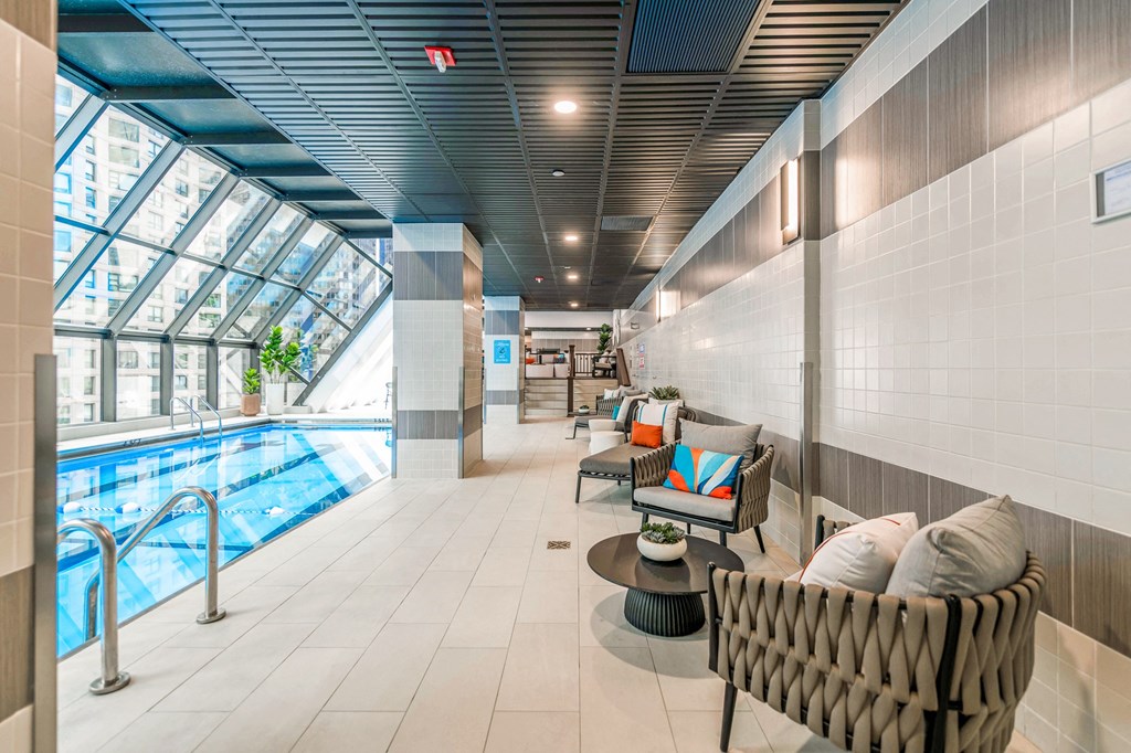 a lobby with a pool and lounge chairs