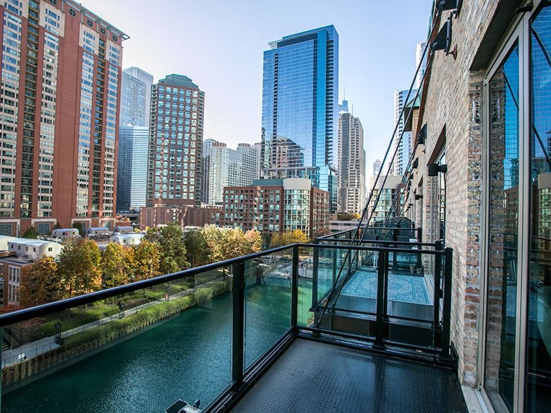 a balcony with a view of the chicago river and skyscrapers