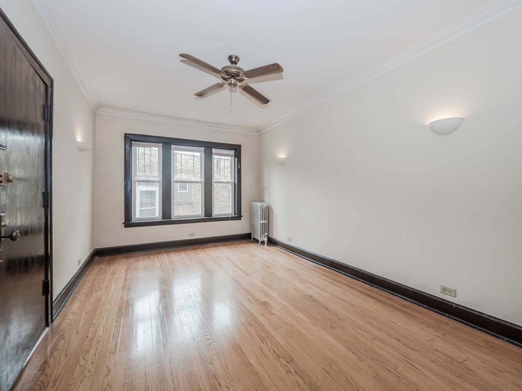 an empty room with hardwood floors and a ceiling fan