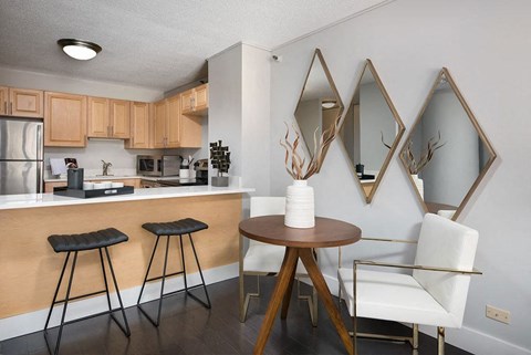 a kitchen with a bar and a table with three stools