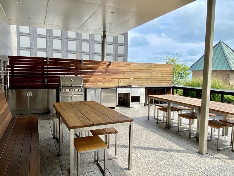 a patio with tables and chairs and a grill