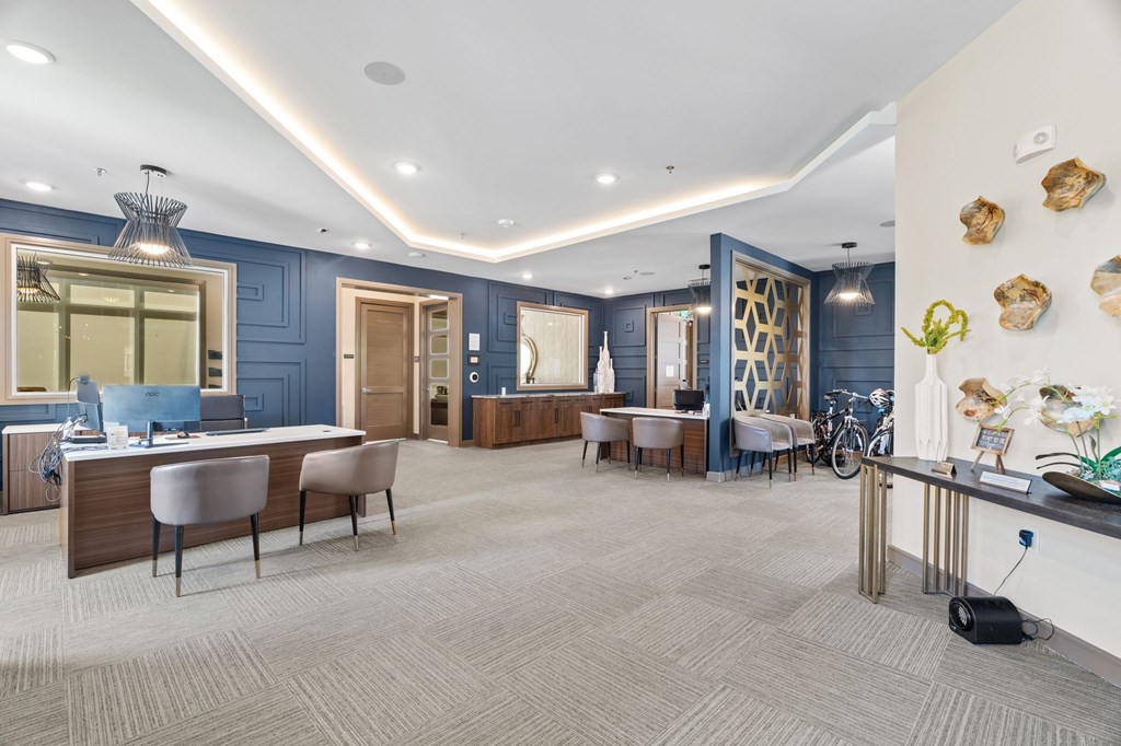 A modern office space with a reception desk and chairs.