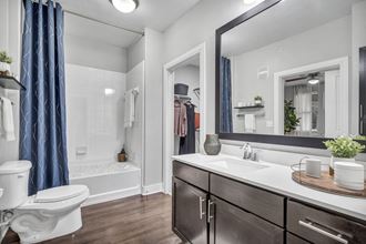 a bathroom with a large mirror and a toilet and a sink