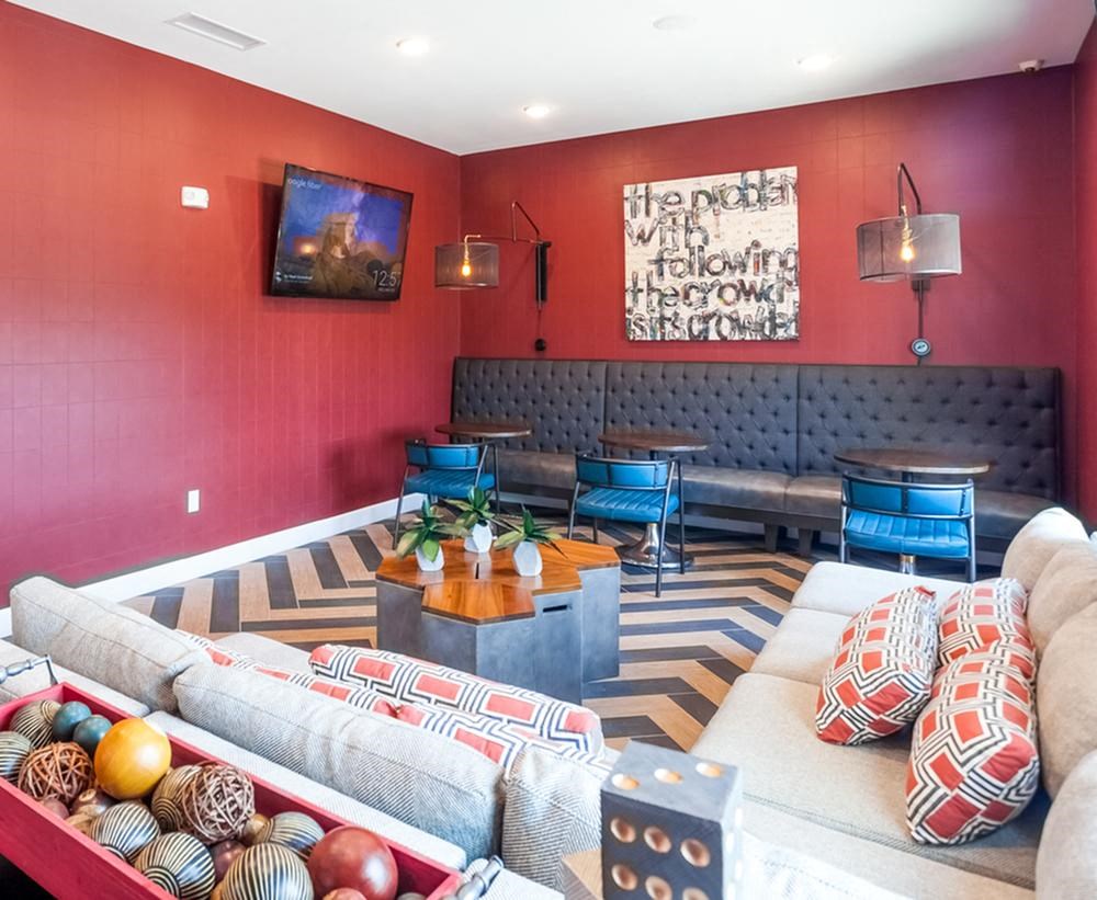 a living room with couches and chairs and a painting on the wall