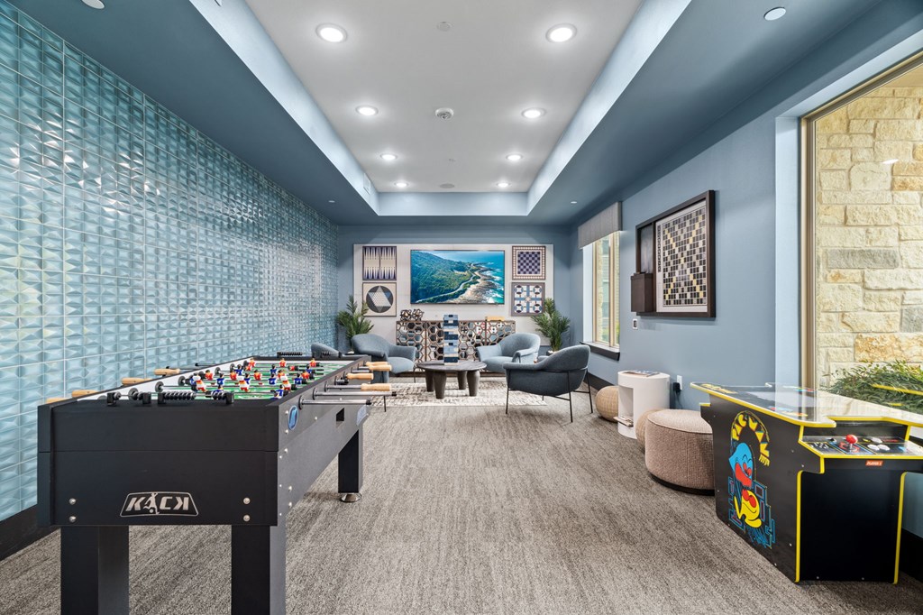 A room with a pool table and a foosball table.