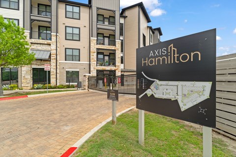 A sign for Axis Hamilton in front of a building.