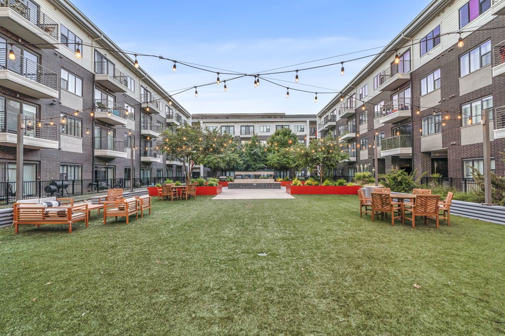 a courtyard with furniture and a fountain in the middle of an apartment complex