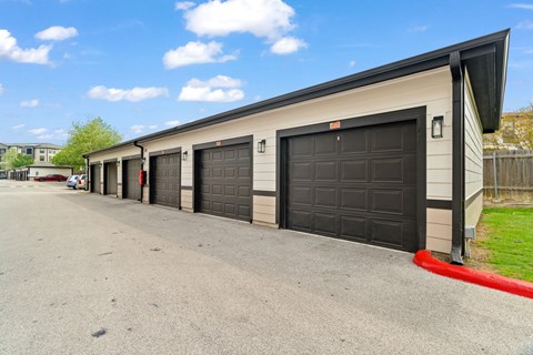 A long building with black garage doors.