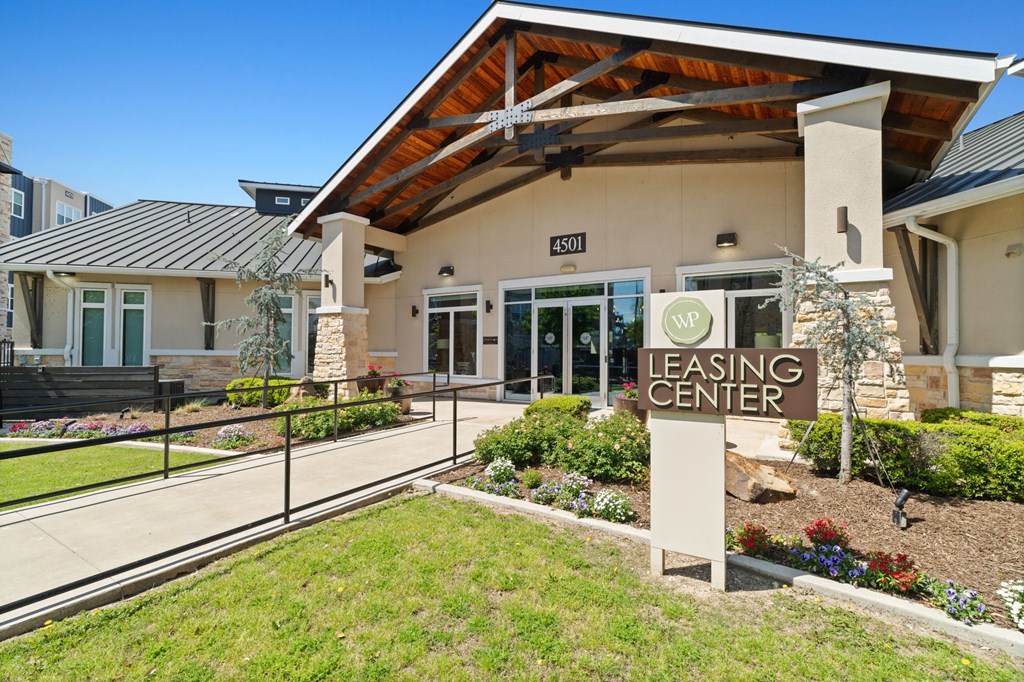 A leasing center with a sign in front of it.