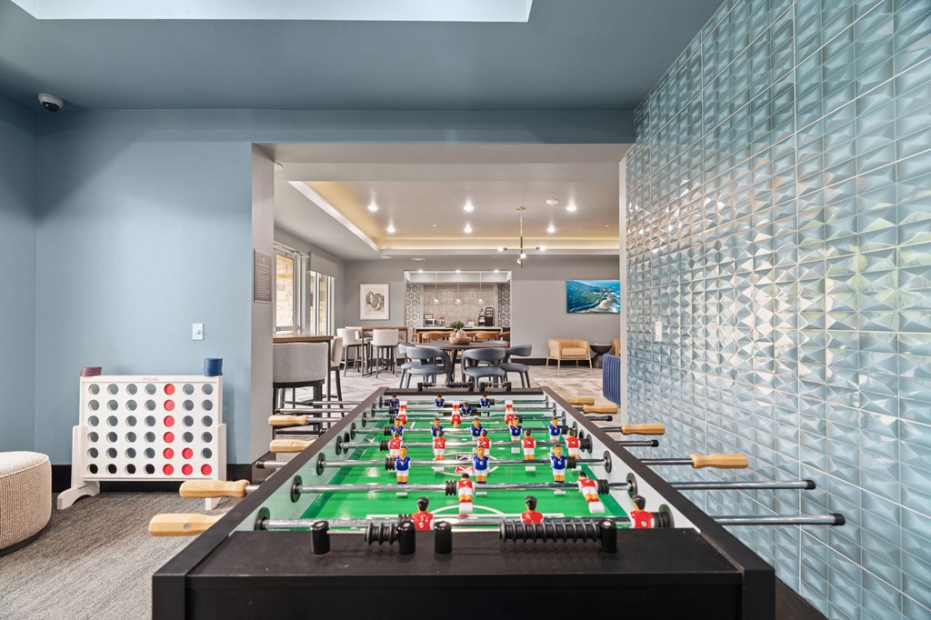 A foosball table is in the middle of a room with a blue wall.