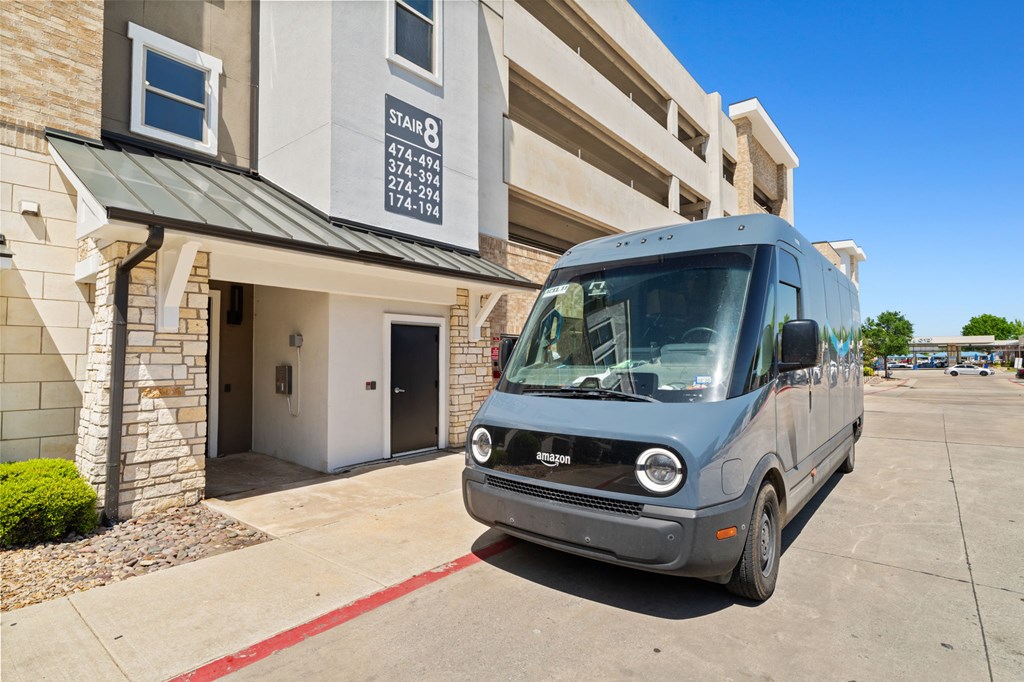 A blue van is parked in front of a building with a sign that reads "STAIR 8".