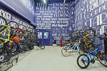 a bunch of bikes parked in a room with a wall with words on it