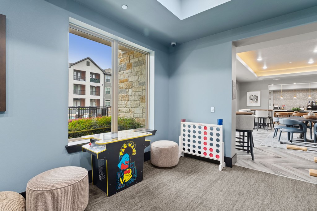 A room with a blue wall and a window showing a building outside.
