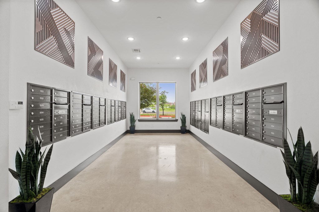 A long hallway with a series of mailboxes on the wall.
