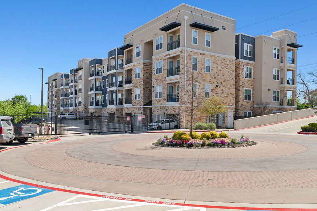 A large apartment complex with a round walkway in front.