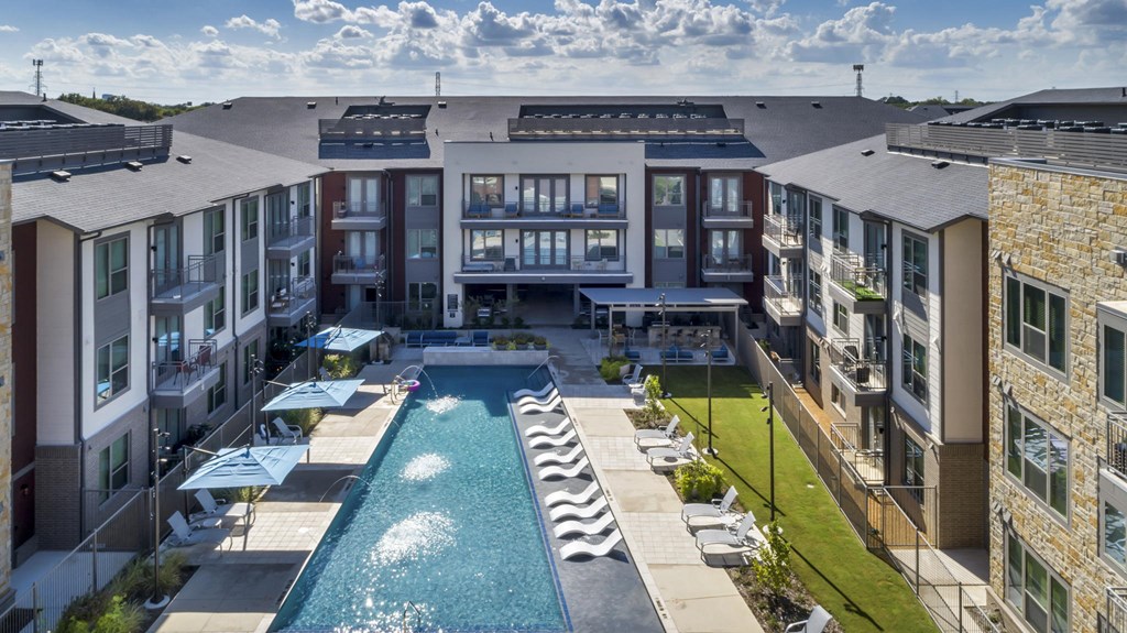 an aerial view of an apartment building with a swimming pool
