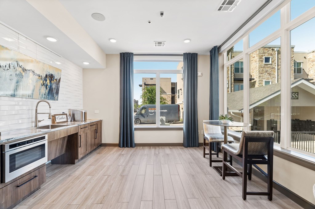 A modern kitchen with wooden floors and a large window.
