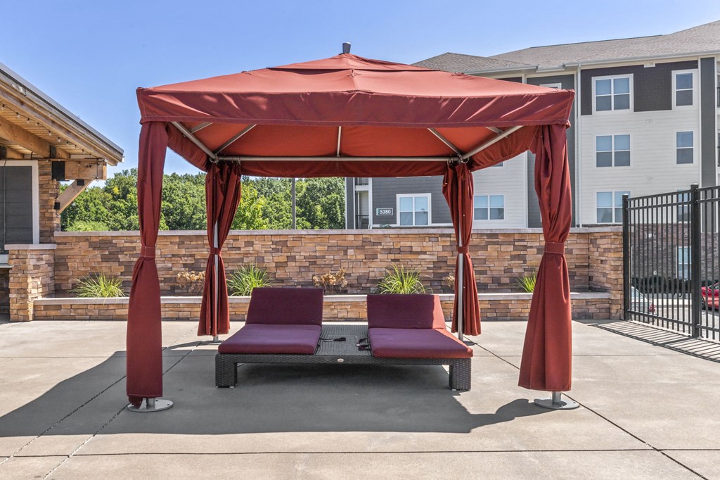 a gazebo with two couches and a table in a courtyard
