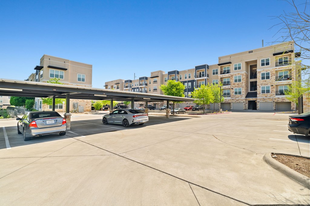 A parking lot with cars and a building in the background.