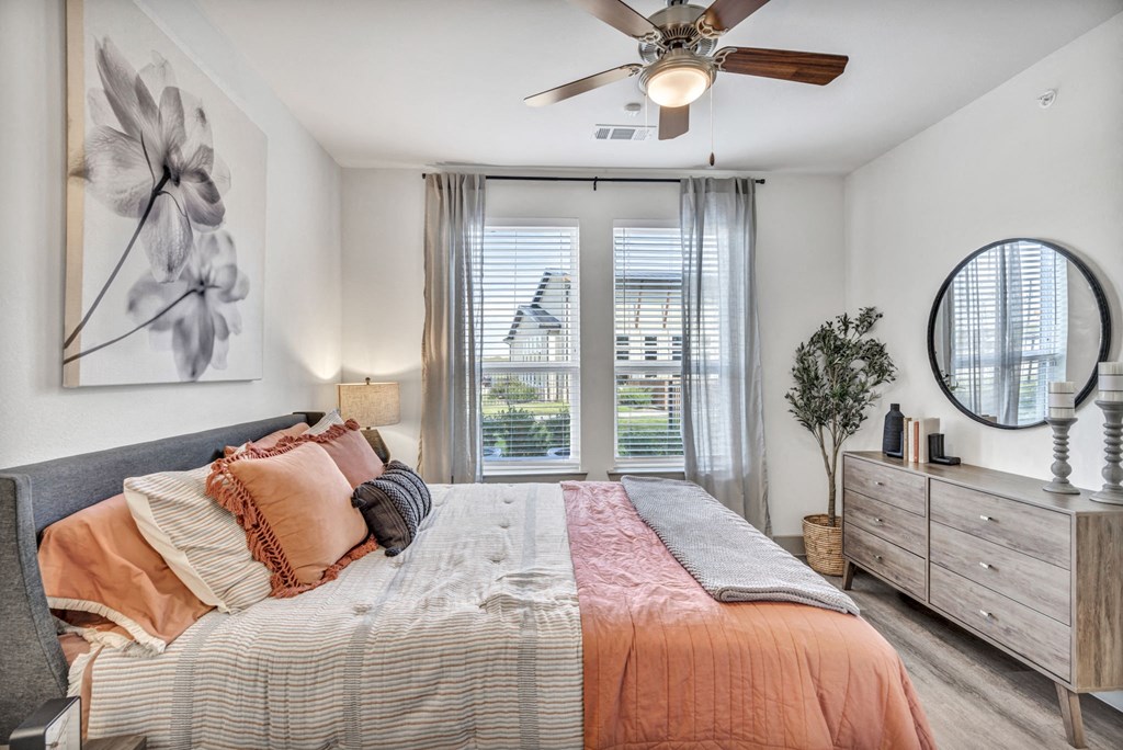a bedroom with a bed and a ceiling fan