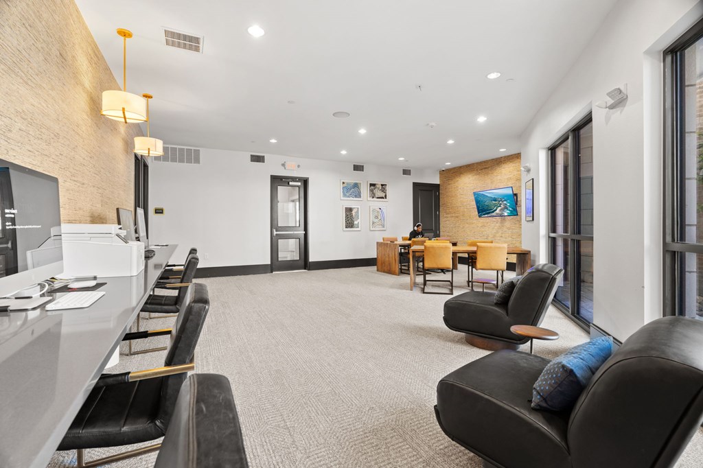 A waiting area with black leather chairs and a white reception desk.