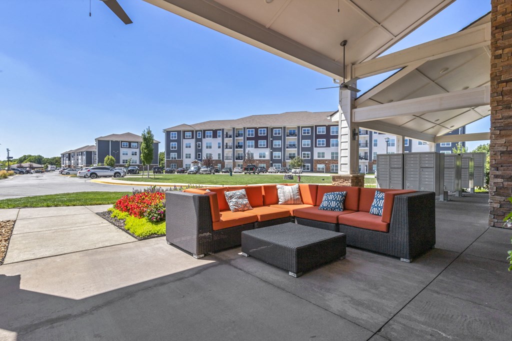 a patio with a couch and a table in front of a building