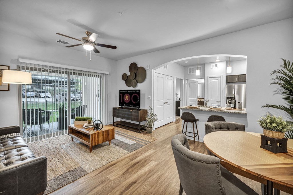 an open living room with a dining room and kitchen and a balcony