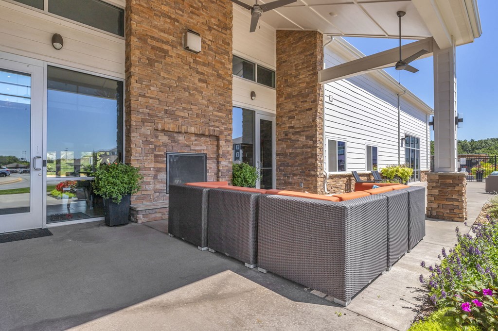 a porch with a fireplace and a building with glass doors