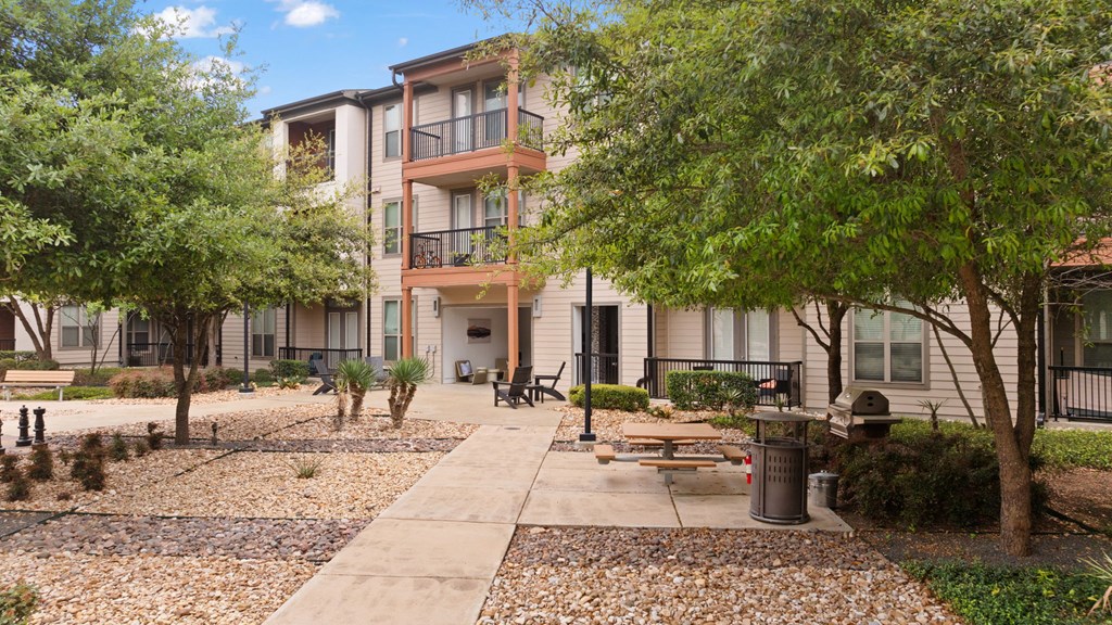 Apartment complex with a walkway and trees.