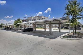 a covered parking lot with a building in the background