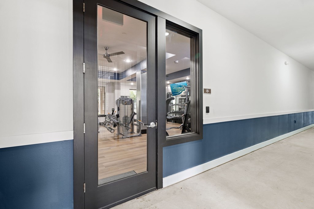 A modern room with a black door and a mirror on the wall.