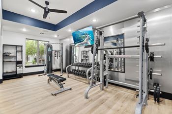 A spacious home gym with a variety of equipment including a squat rack, bench, and weights.