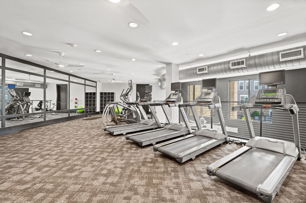 A gym with treadmills and other exercise equipment.