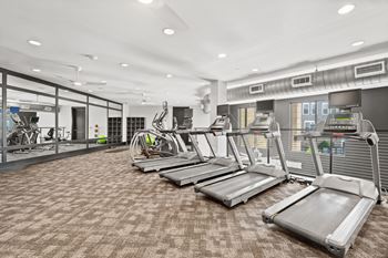 A gym with treadmills and other exercise equipment.