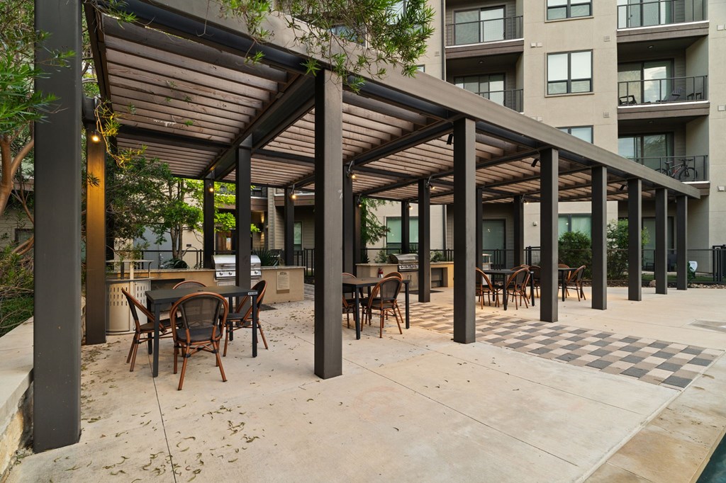 A patio with a table and chairs under a roof.