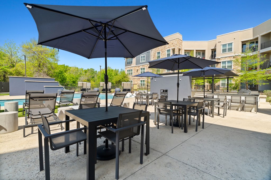 A patio with black furniture and umbrellas.
