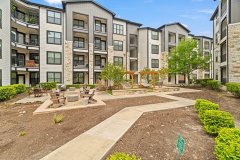 Apartment complex with a small garden in front.
