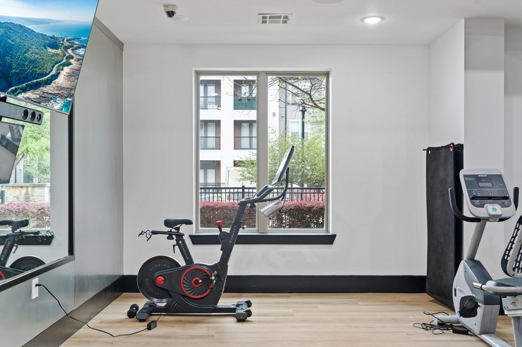 A room with a stationary bike and a treadmill.