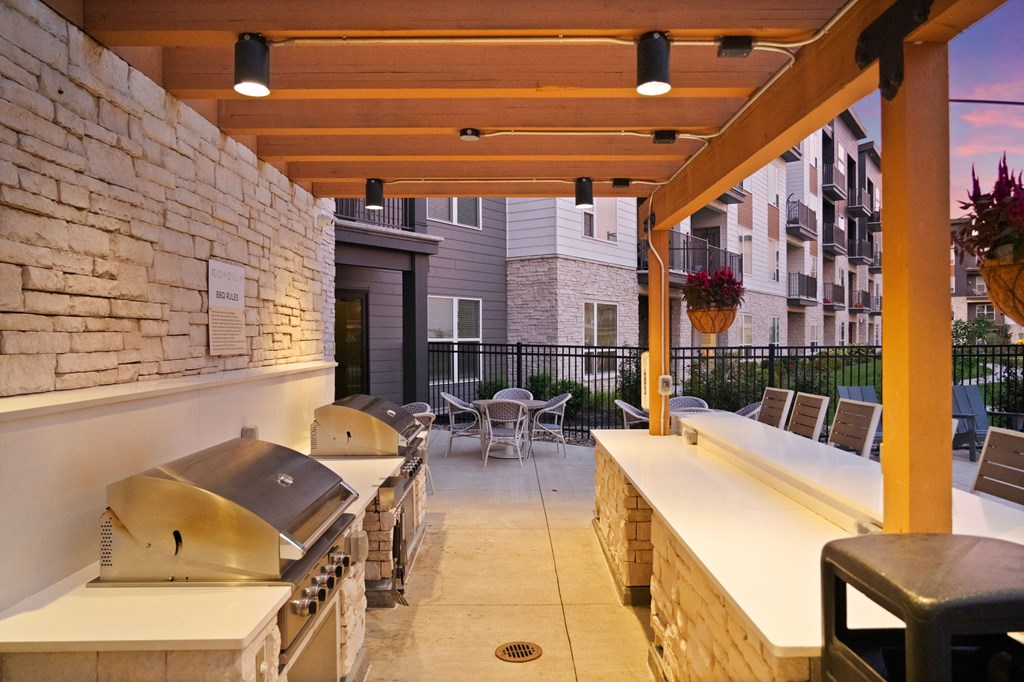 a covered patio with barbecue grills and tables