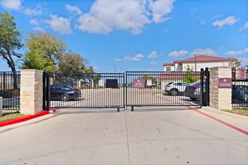 the gate at the entrance of a parking lot with cars