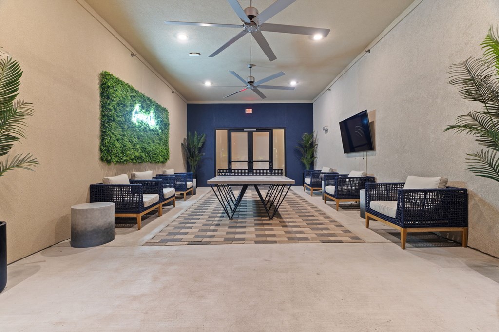 A room with a green wall hanging and a ceiling fan.
